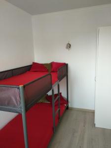 センノイにあるГостевой домのベッドルーム1室(赤いシーツを使用した二段ベッド2組付)