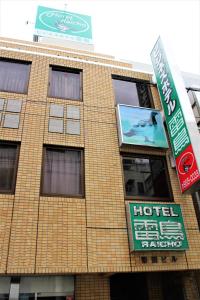 un edificio con dei cartelli sul lato di Business Hotel Raicho a Koshigaya