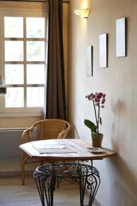 a table with a vase of flowers and a window at La Bergerie De Valerie in Arthès
