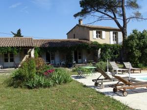 a house with benches and a pool in front of it at La Coudoulière in Saint-Rémy-de-Provence