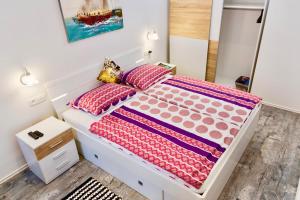 een slaapkamer met een wit bed met roze kussens bij Luxury Villa Minerva Gardens in Split