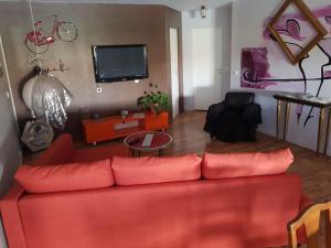 ein Wohnzimmer mit einem roten Sofa und einem TV in der Unterkunft le Tic Tac in Vergongheon