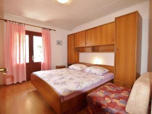 a small bedroom with a bed and a cabinet at Apartmani Danijela Lopar in Lopar