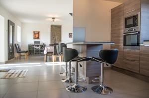 a kitchen with a counter and stools in a room at Cap sur Pen ar Valy à Plougoulm in Plougoulm