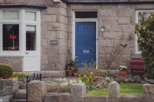 a blue door on a stone house with a cemetery at Firhurst in Aboyne