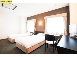 Smile Hotel Asahikawa tesisinde bir odada yatak veya yataklar