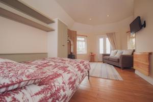 1 dormitorio con cama, sofá y TV en Firhurst en Aboyne