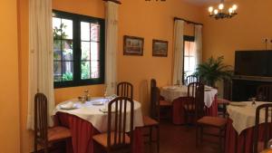 een eetkamer met 2 tafels met witte tafellakens bij Hotel Casa Rural San Antón in Chinchón