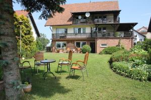 a yard with chairs and a table in front of a house at AS Gościniec in Mikołajki