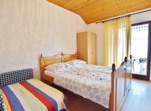 a bedroom with two beds and a window at Apartmani Danijela Lopar in Lopar