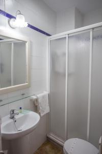 a bathroom with a shower and a sink and a toilet at Hostal Santa Catalina in Conil de la Frontera