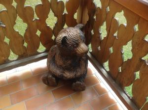 una statua di un orso seduto di fronte a una recinzione di Petit Ours a Villars-sur-Ollon