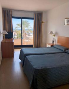 a bedroom with a bed and a view of a balcony at Hotel el Paraiso in Caleta De Velez