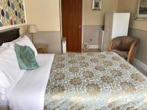 Acorn Guest House in Hull في هال: غرفة نوم بسرير كبير ومخدة خضراء عليها