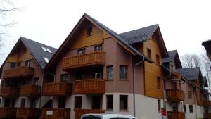 an apartment building with wooden balconies on it at Apartament LUX in Karpacz