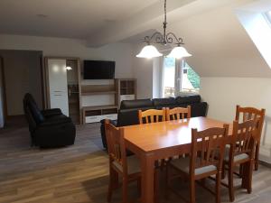 Una sala de estar con una mesa y sillas y un sofá. en Apartmaji Zupan, en Bohinjska Bela