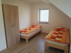 Un dormitorio con dos camas y una ventana. en Apartmaji Zupan, en Bohinjska Bela
