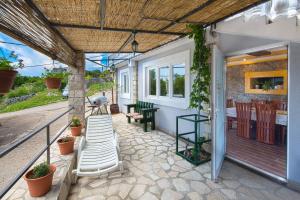 an outdoor patio with a white ladder and a table at Apartman Kunjić in Krimovice