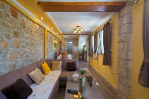 a living room with a couch and a stone wall at Apartman Kunjić in Krimovice