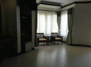 ein Wohnzimmer mit einem Tisch, Stühlen und einem Fenster in der Unterkunft Golden Beach Resort in Ao Nang Beach