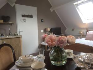 a vase of flowers on a table with a bed at Bed & Breakfast Yerseke in Yerseke