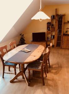 a wooden table and chairs in a living room at hotel zentlinde in Mossautal