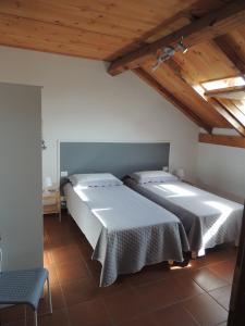 Dos camas en una habitación con techos de madera. en La Darsena, en La Spezia
