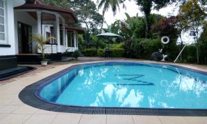 a swimming pool in front of a house at Sama Uyana Holiday Bungalow in Gampola