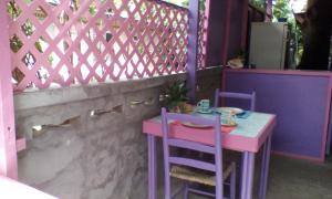 a pink and purple table and chairs next to a fence at Somewhere Special Guesthouse in Gros Islet