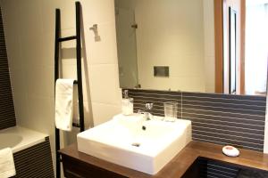 a bathroom with a white sink and a mirror at Feel Coimbra Apartments in Coimbra