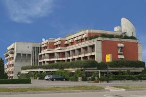 un edificio con un'auto parcheggiata di fronte di Hotel Pergola a Legnago