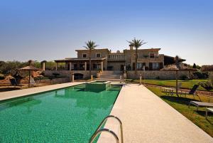 a house with a swimming pool in front of a house at Canova in Ariany