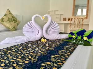 two white swans are sitting on a bed at Narayana Homestay in Amed +30 photos