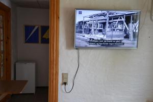 een televisie aan een muur met een foto van een gebouw bij Markvænget 5 in Sønder Felding