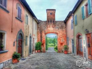 an alley in an old stone building with a tower at Affittacamere La Loggia in Altopascio