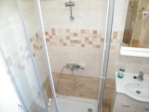 een badkamer met een douche en een wastafel bij Apartmani Mirista in Herceg-Novi