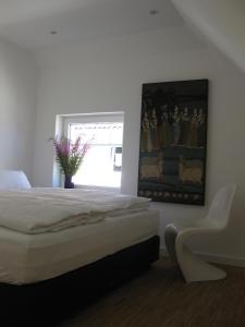 a bedroom with a bed and a painting on the wall at Blue House Rügen in Altenkirchen
