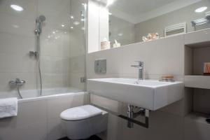 biała łazienka z umywalką i toaletą w obiekcie Apartamenty Starówka - Melody w Szczecinie +31 zdjęć