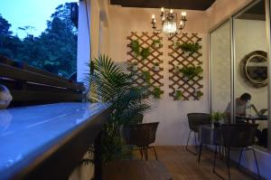 Eine Bar mit Pflanzen und ein Mann, der an einem Tisch sitzt. in der Unterkunft Sleepbox Hotel in Cameron Highlands