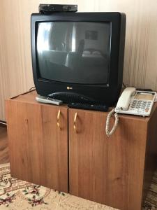 a tv on a cabinet with a phone and a laptop at Гостиница Альянс in Karagandy +30 photos