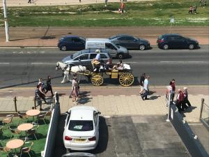 a horse drawn carriage on a city street with people at Sea Princess Hotel Blackpool in Blackpool