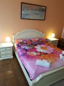 a bedroom with a bed with a flower blanket at Casa Veneta in Martignacco