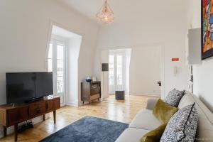 un soggiorno con divano e TV a schermo piatto di Estefânia RoofTop Apartment - Lisbon Center (NEW) a Lisbona