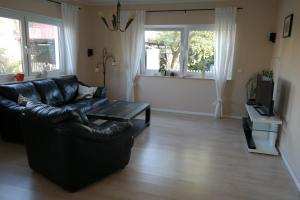 a living room with a black leather couch and a table at Ferienhaus Frankstraße 5b in Zinnowitz