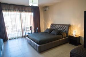 1 dormitorio con cama y ventana grande en Acitrezza B&B, en Aci Trezza