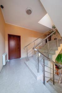 a metal staircase in a room with a wooden door at Gorka Guest House in Lazarevskoye