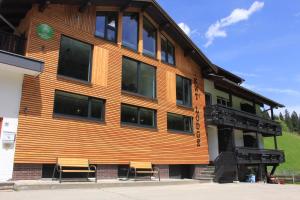 a wooden building with two benches in front of it at KWT Lodge in Mittelberg