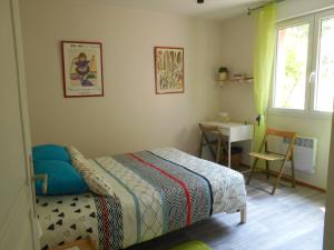 una camera da letto con un letto, un tavolo e una finestra di chez Isabelle a Auterive