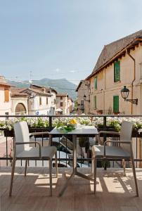 una mesa y sillas sentadas en un balcón con vistas en B&B La Bellavita del Garda Luxury, en San Felice del Benaco