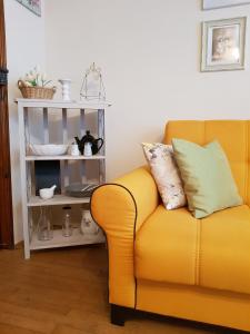 a yellow couch in a living room with a shelf at Apartment Georgi Baev in Burgas